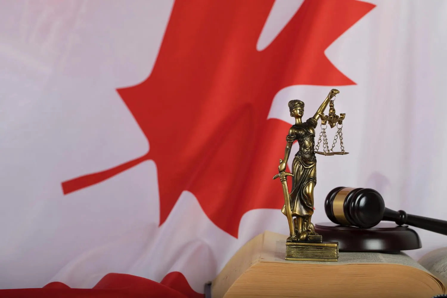 themis figurine in front of canada flag