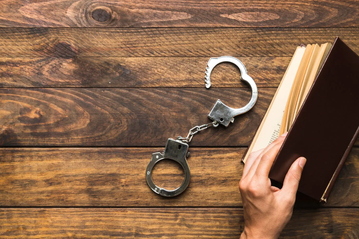 handcuffs next to a law book